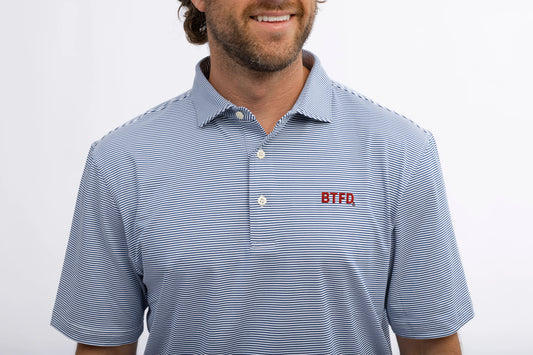 Man wearing a blue striped golf polo shirt with an embroidered 'BTFD' logo on a white background