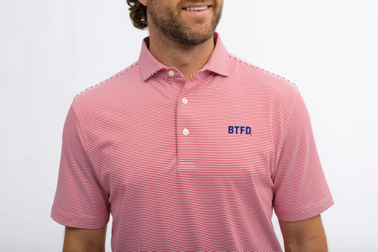 Man wearing a red striped golf polo shirt with an embroidered 'BTFD' logo on a white background