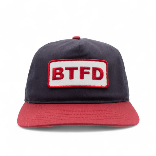 Navy and red cotton twill cap with embroidered 'BTFD' patch on a white background