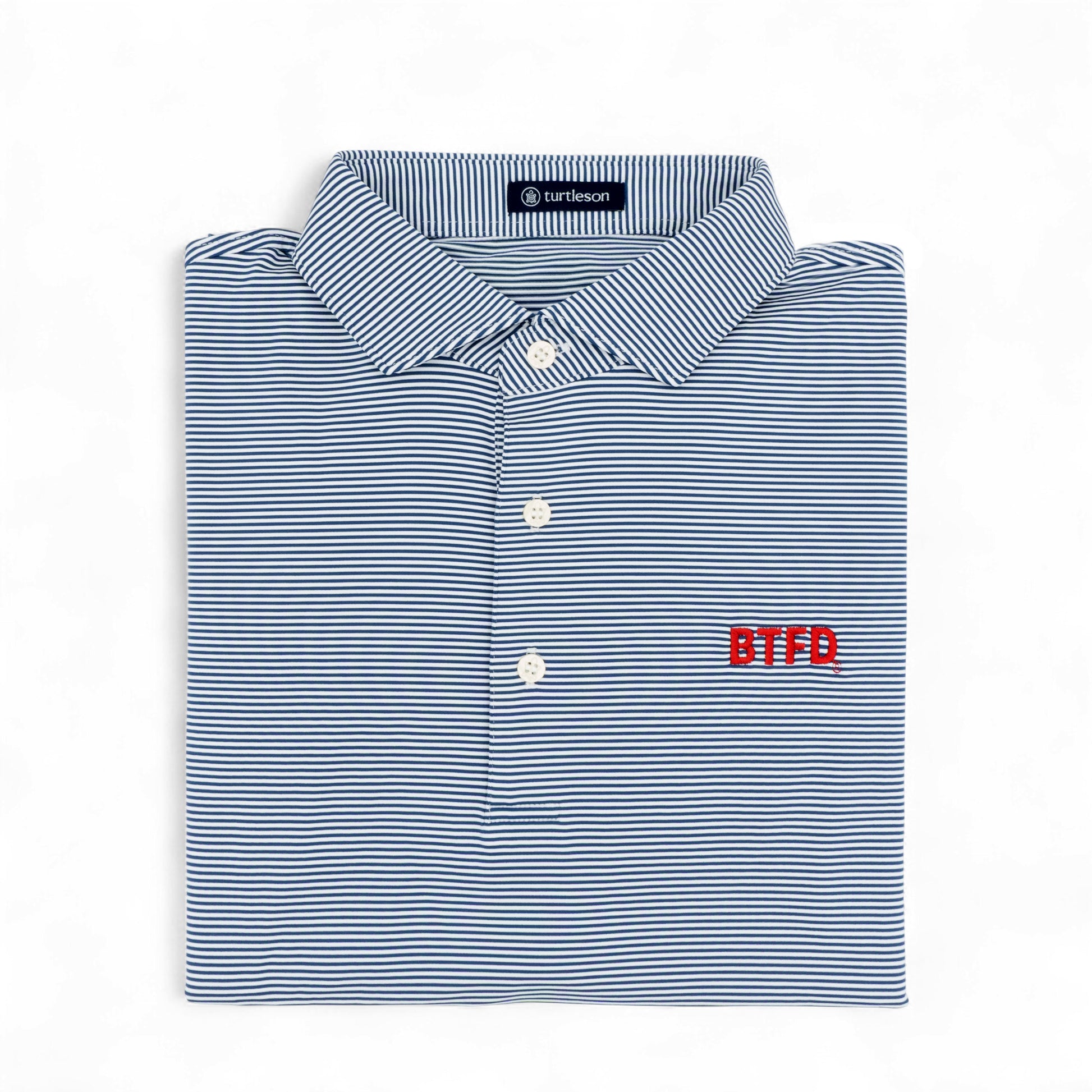 Folded blue and white striped golf shirt with 'BTFD' logo on a white background