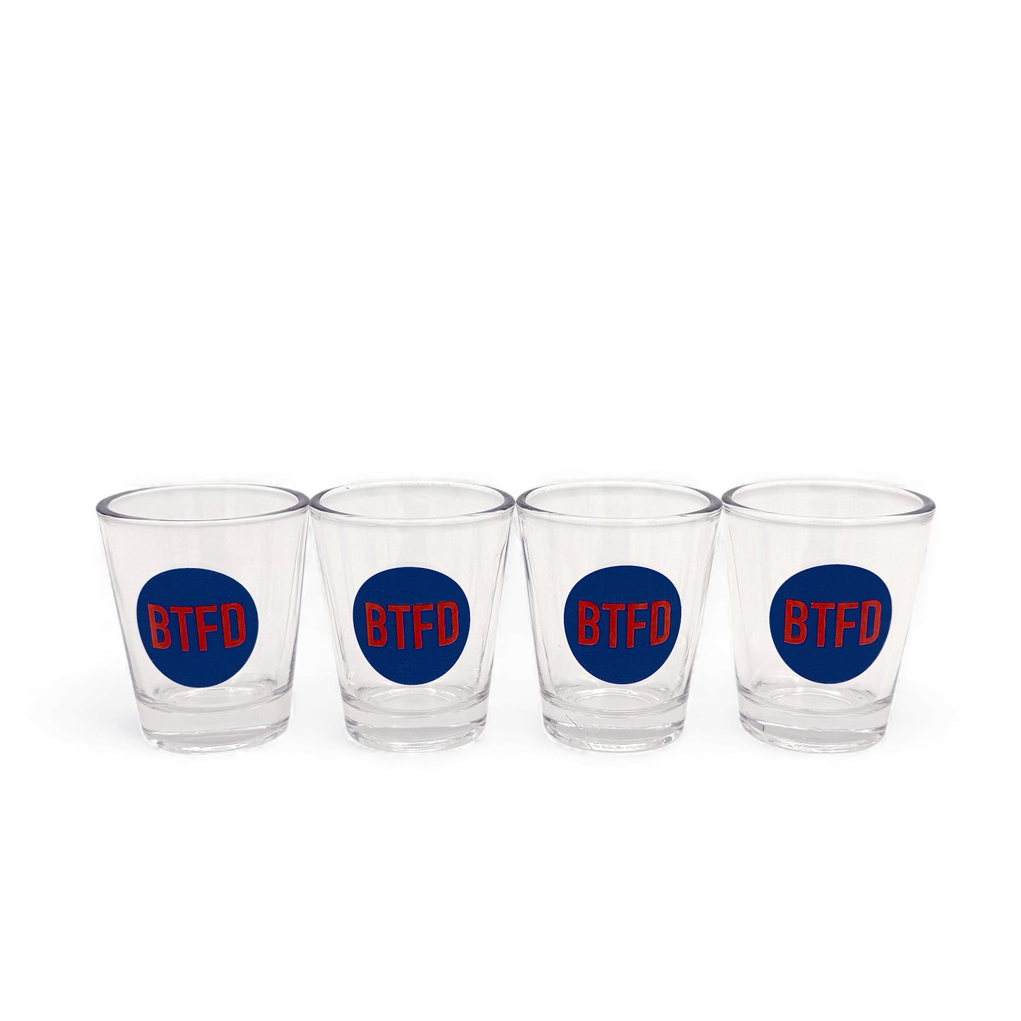 Four clear shot glasses with a blue circle designs and 'BTFD' text on a white background
