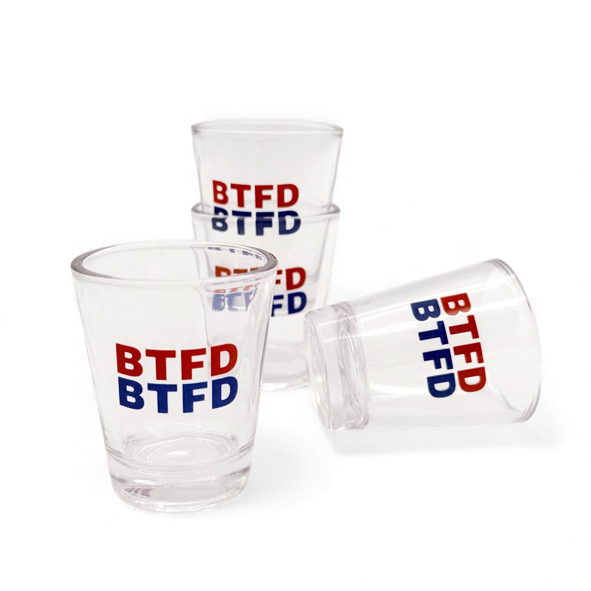 Set of 4 clear shot glasses with 'BTFD' text in red and blue on a white background