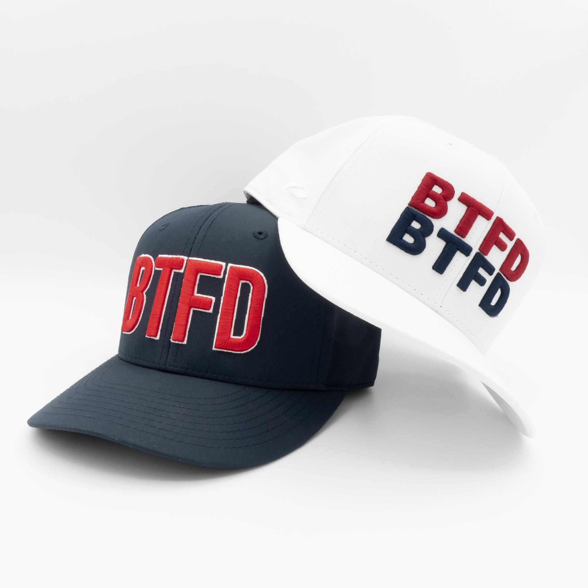 Two hats, one navy and one white, with 'BTFD' text on a light gray background