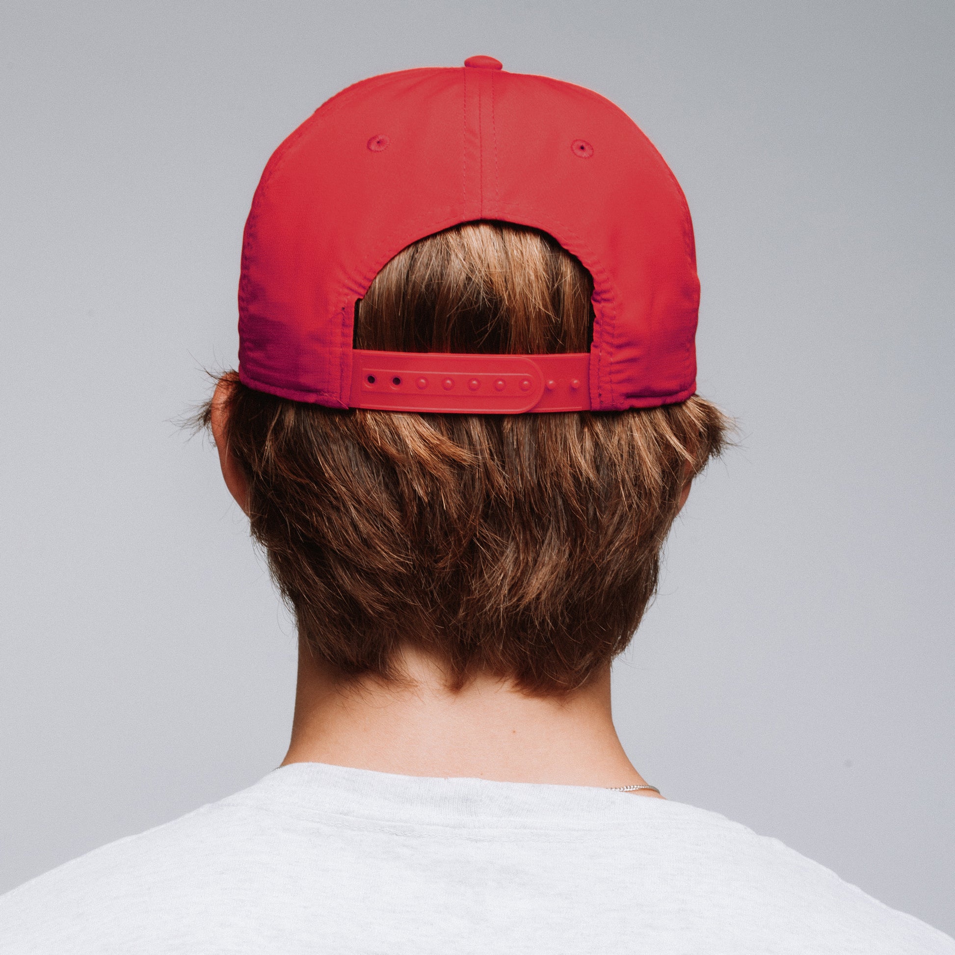 back of a red snapback hat on a person